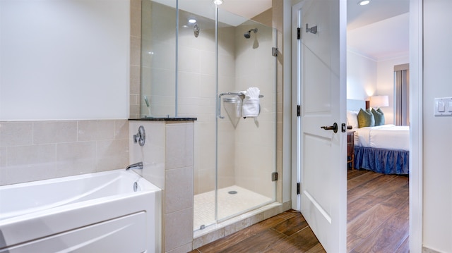 bathroom with ornamental molding, hardwood / wood-style floors, and plus walk in shower