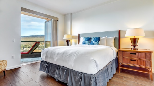 bedroom featuring access to outside, multiple windows, hardwood / wood-style flooring, and ornamental molding