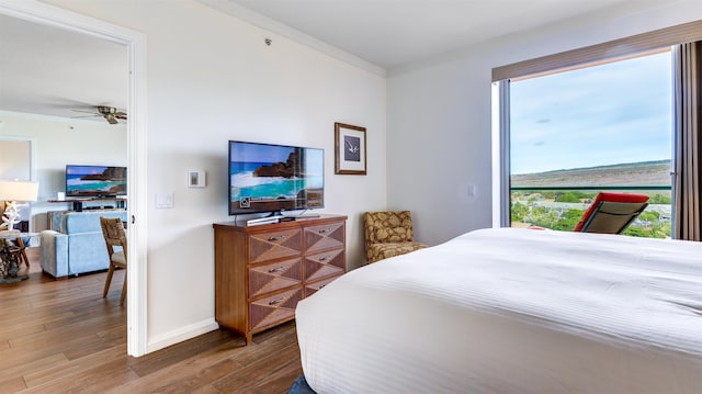 bedroom with ornamental molding and hardwood / wood-style floors