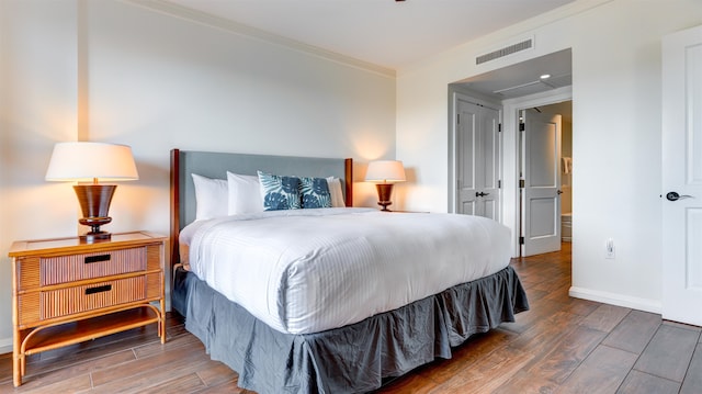 bedroom featuring wood-type flooring and crown molding