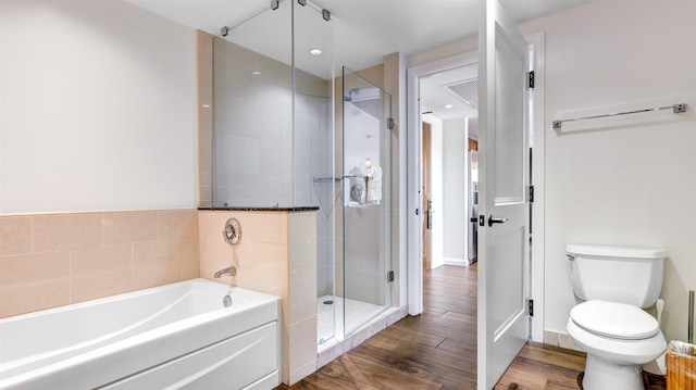 bathroom featuring hardwood / wood-style floors, toilet, and plus walk in shower