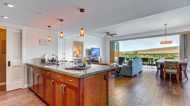 kitchen featuring pendant lighting, light wood-type flooring, ceiling fan, and light stone counters