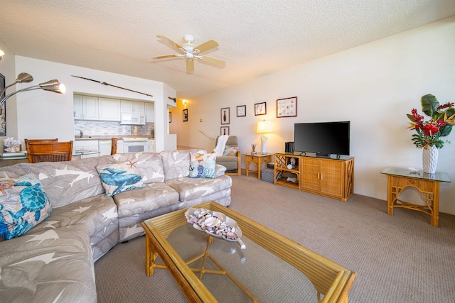 carpeted living room with ceiling fan and a textured ceiling