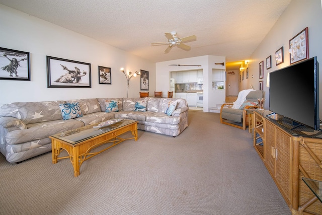 carpeted living room featuring ceiling fan and a textured ceiling