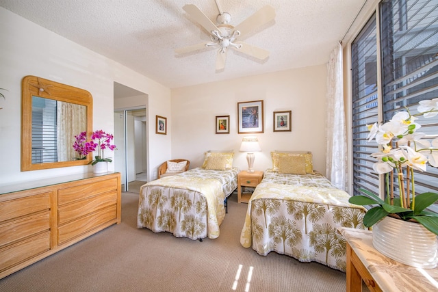 bedroom with carpet flooring, a textured ceiling, a closet, and ceiling fan