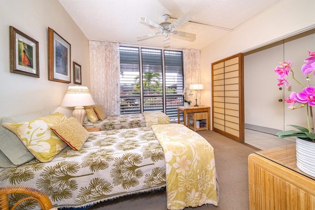 bedroom with ceiling fan, light carpet, and a textured ceiling