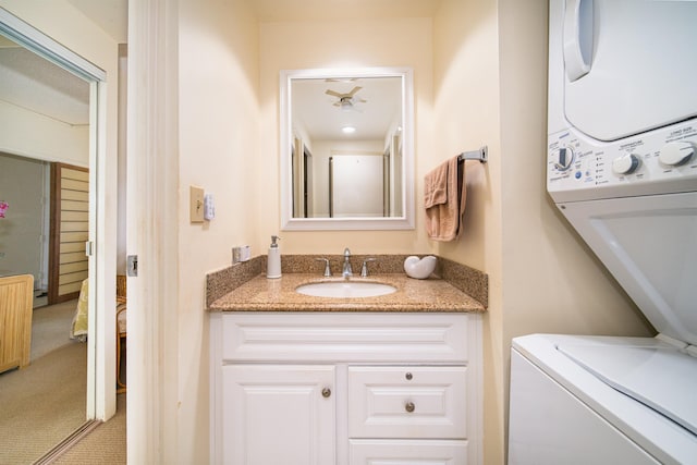 bathroom featuring stacked washer and dryer and vanity