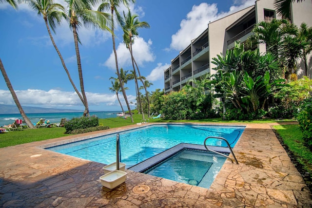 view of pool with a water view and a hot tub