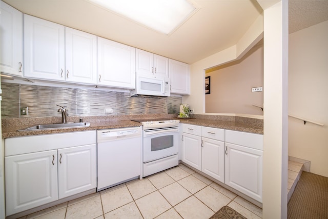 kitchen featuring tasteful backsplash, white appliances, sink, light tile patterned floors, and white cabinets