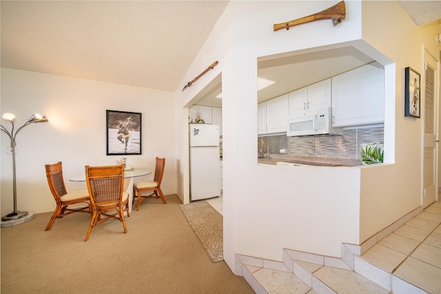 kitchen featuring white cabinets, white appliances, light colored carpet, and tasteful backsplash