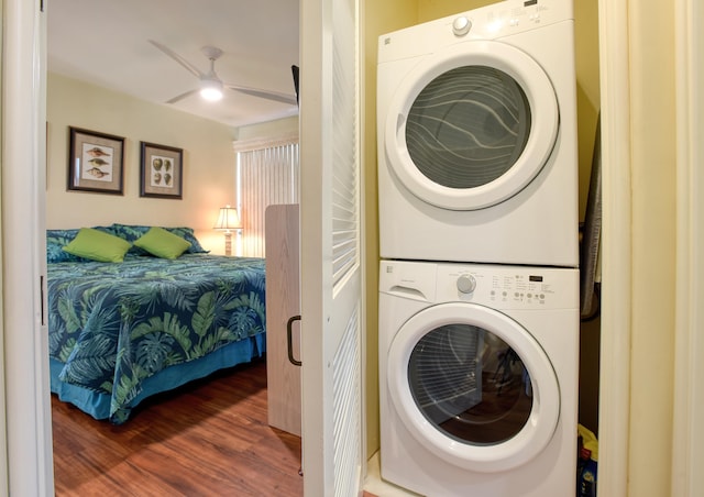 washroom featuring dark hardwood / wood-style floors, ceiling fan, and stacked washer and dryer