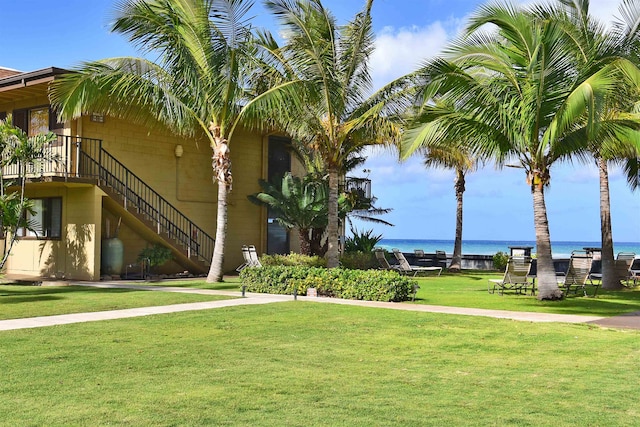 view of home's community featuring a lawn and a water view