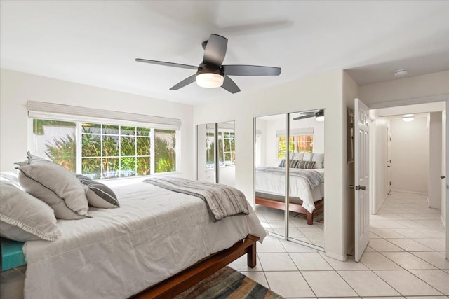 bedroom with a ceiling fan, light tile patterned flooring, and two closets