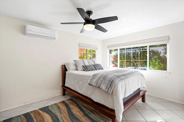 bedroom with light tile patterned floors, an AC wall unit, a ceiling fan, and baseboards