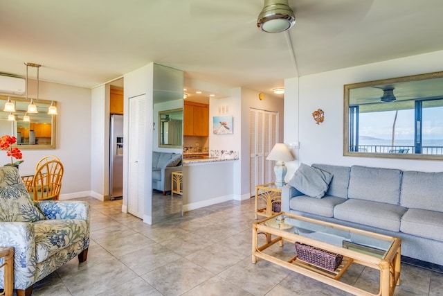 tiled living room featuring ceiling fan and an AC wall unit