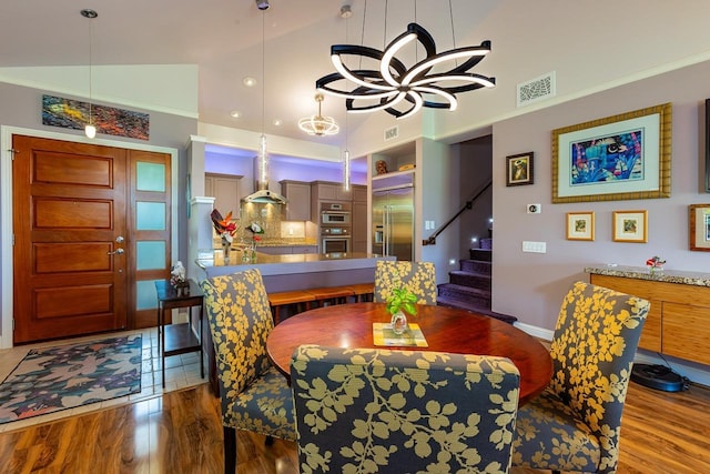 dining room with vaulted ceiling, wood-type flooring, and ornamental molding