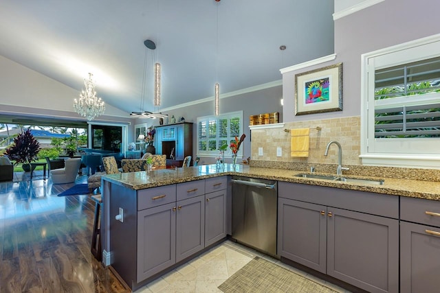 kitchen featuring hanging light fixtures, light stone countertops, stainless steel dishwasher, sink, and kitchen peninsula