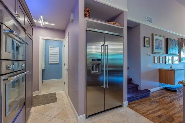 kitchen with dark brown cabinets and built in refrigerator