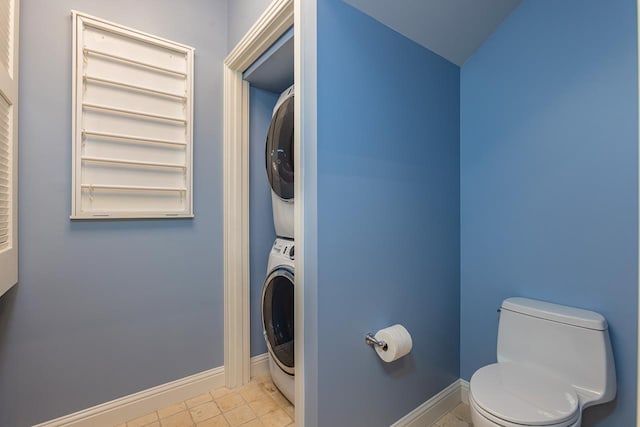 washroom featuring light tile patterned floors and stacked washer / drying machine