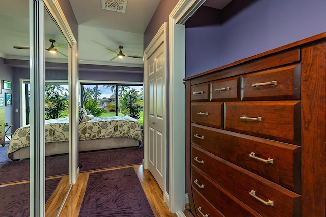 corridor with hardwood / wood-style floors and ornamental molding