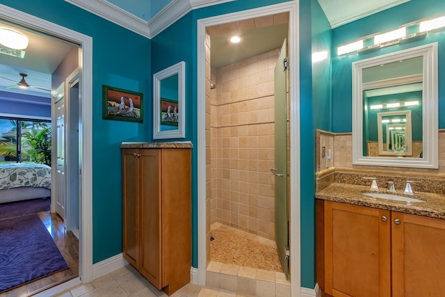 bathroom with tiled shower, tile patterned flooring, vanity, and backsplash