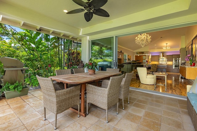 sunroom featuring ceiling fan with notable chandelier and lofted ceiling