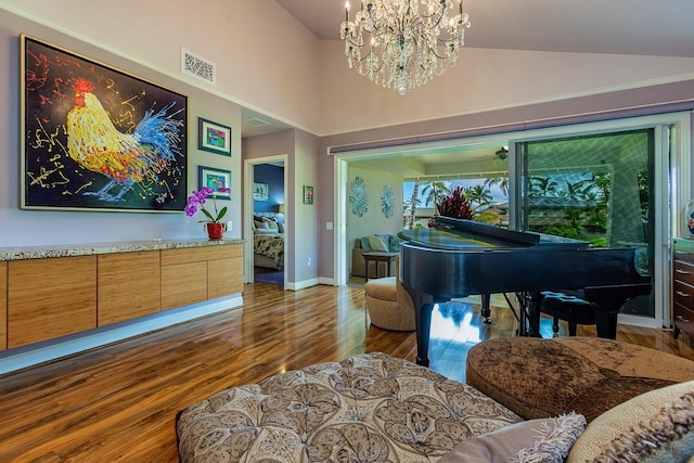 living area featuring an inviting chandelier, vaulted ceiling, and dark wood-type flooring