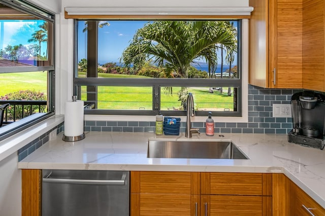 10 Wailea Ekolu Pl Unit 1204, Kihei, HI 96753 - kitchen featuring stainless steel dishwasher, brown cabinets, backsplash, and light stone countertops