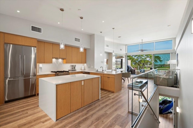 209 Holokahiki Ln Unit 103, Kihei, HI 96753 - kitchen with a sink, high end refrigerator, visible vents, a peninsula, and a kitchen island