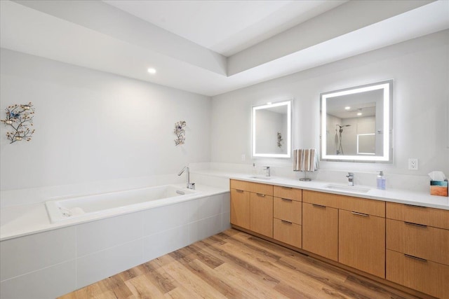 209 Holokahiki Ln Unit 103, Kihei, HI 96753 - bathroom with recessed lighting, a sink, a bath, double vanity, and wood finished floors
