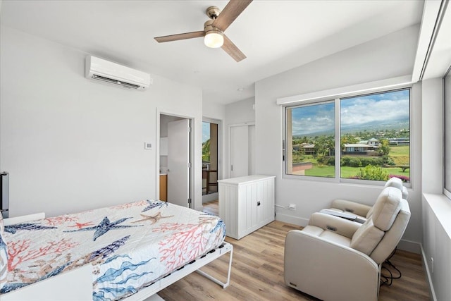 209 Holokahiki Ln Unit 103, Kihei, HI 96753 - bedroom featuring baseboards, a wall unit AC, a ceiling fan, and light wood-style flooring