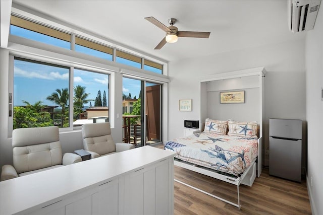 209 Holokahiki Ln Unit 103, Kihei, HI 96753 - bedroom featuring wood finished floors, freestanding refrigerator, a wall mounted air conditioner, access to exterior, and a ceiling fan