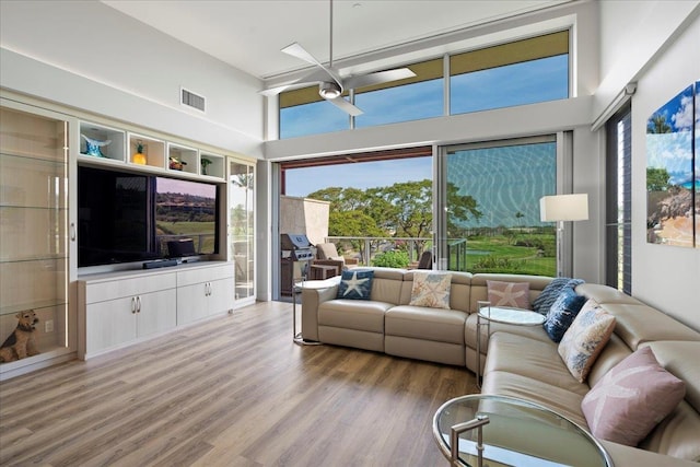 209 Holokahiki Ln Unit 103, Kihei, HI 96753 - living area with visible vents, a ceiling fan, light wood finished floors, and a towering ceiling
