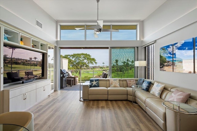209 Holokahiki Ln Unit 103, Kihei, HI 96753 - living room featuring a towering ceiling, visible vents, and light wood finished floors