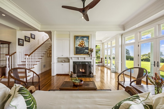 sunroom with a fireplace, ceiling fan, and french doors