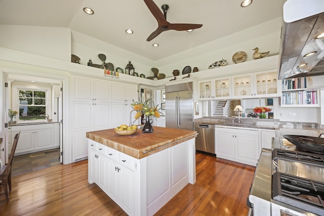 kitchen featuring white cabinets, dark hardwood / wood-style floors, lofted ceiling, a kitchen island, and appliances with stainless steel finishes