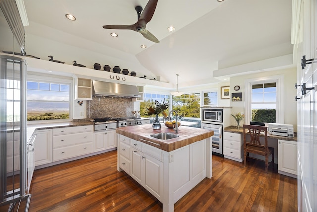 kitchen with wall chimney exhaust hood, a center island, white cabinets, and dark hardwood / wood-style flooring