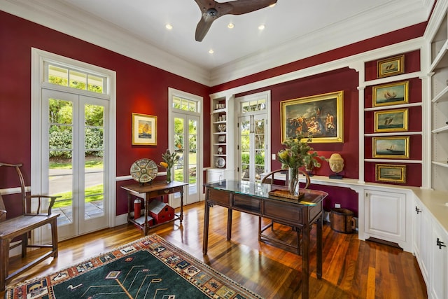 home office with built in shelves, crown molding, french doors, and dark wood-type flooring