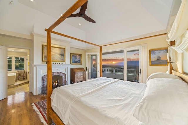 bedroom featuring high vaulted ceiling, access to outside, ceiling fan, a fireplace, and wood-type flooring