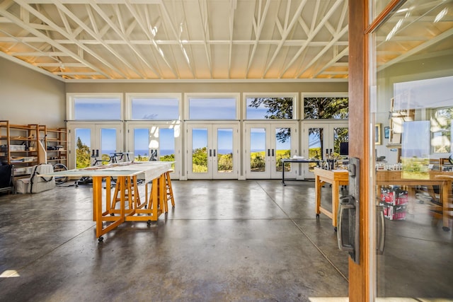 interior space featuring a workshop area, french doors, and a high ceiling