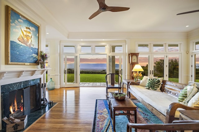 sunroom featuring a fireplace, french doors, ceiling fan, and a healthy amount of sunlight