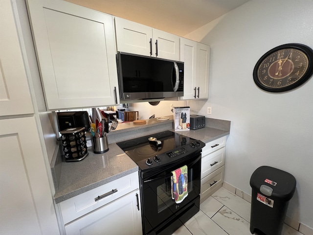 kitchen featuring white cabinets and black / electric stove