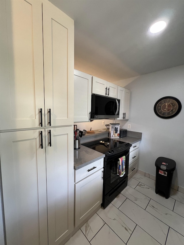 kitchen featuring electric range, white cabinetry, and stone counters