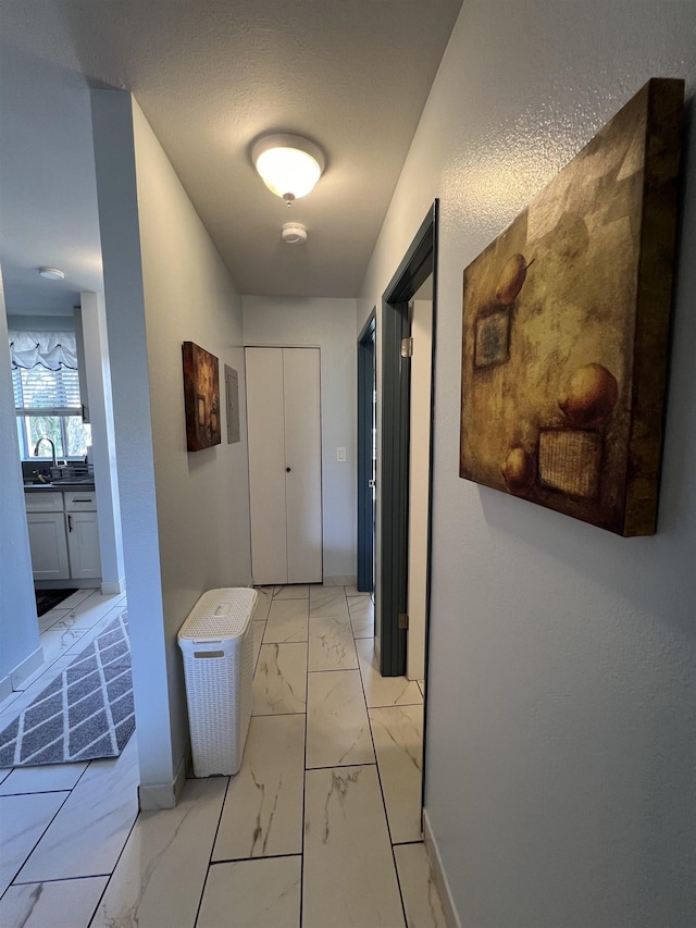 hall featuring sink and a textured ceiling