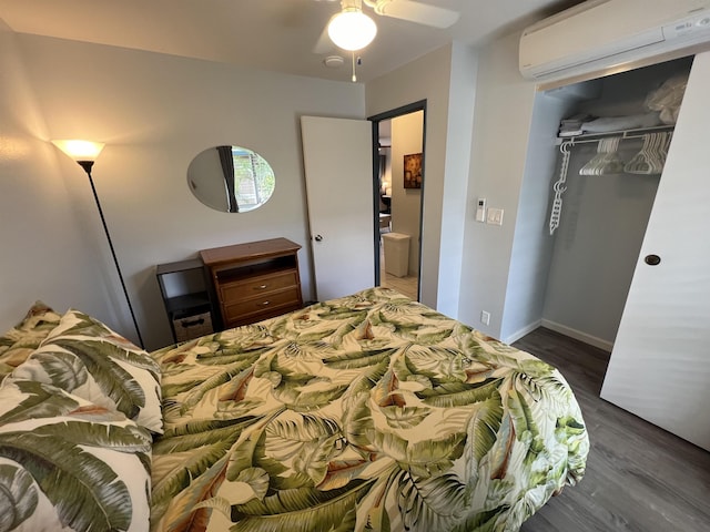 bedroom featuring a wall mounted AC, ceiling fan, a closet, and dark hardwood / wood-style flooring