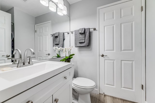 bathroom with hardwood / wood-style floors, toilet, and vanity