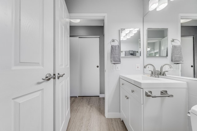 bathroom featuring hardwood / wood-style floors, vanity, and toilet