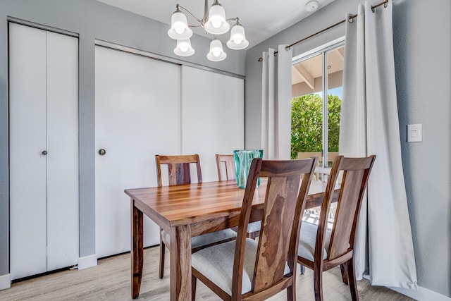 dining area with light wood-type flooring and a chandelier