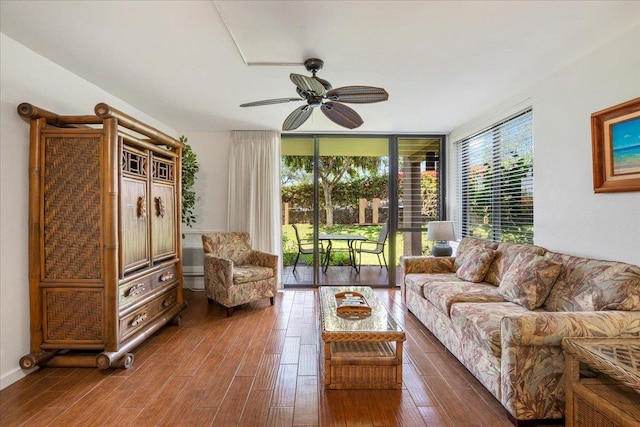 living area featuring a ceiling fan, a healthy amount of sunlight, dark wood finished floors, and floor to ceiling windows