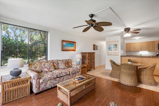 living area with ceiling fan and wood finished floors